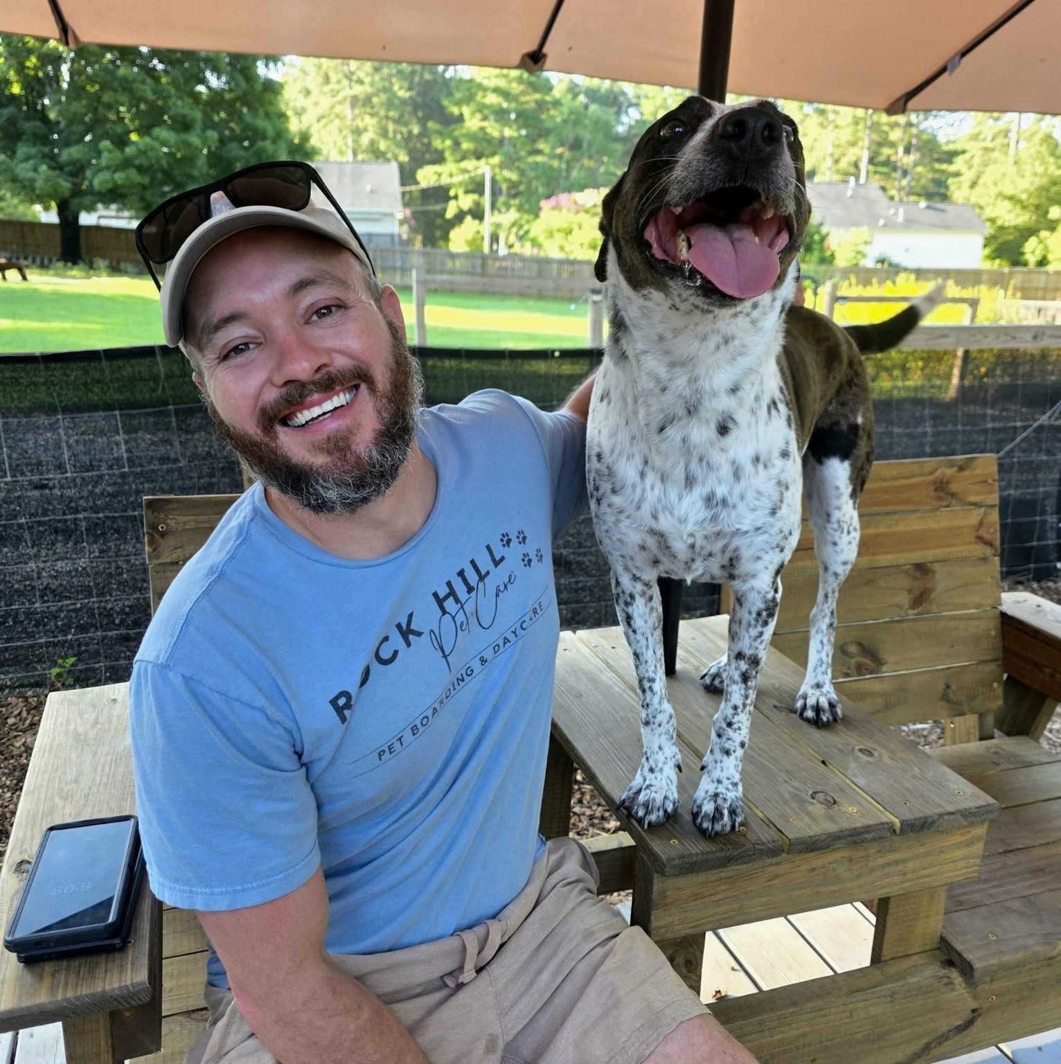 Trenton Madden spending time with a dog in the Rock Hill Pet Care yard